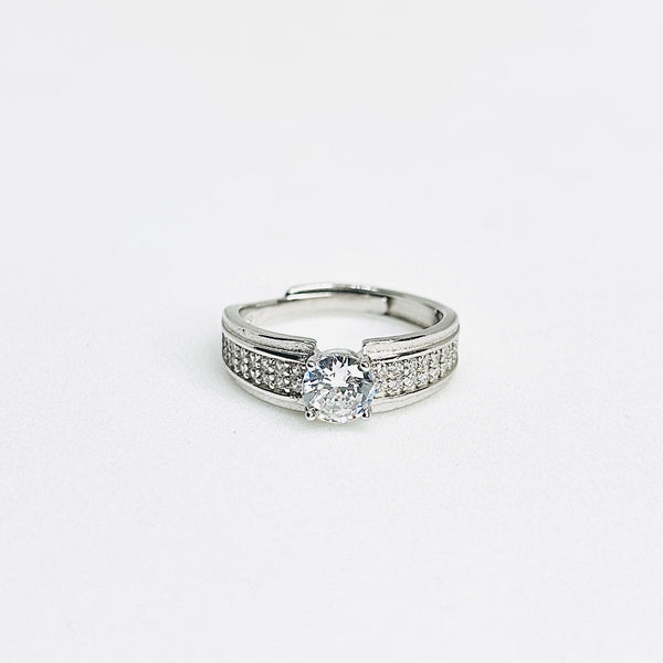 Silver ring with a diamond on a light gray background