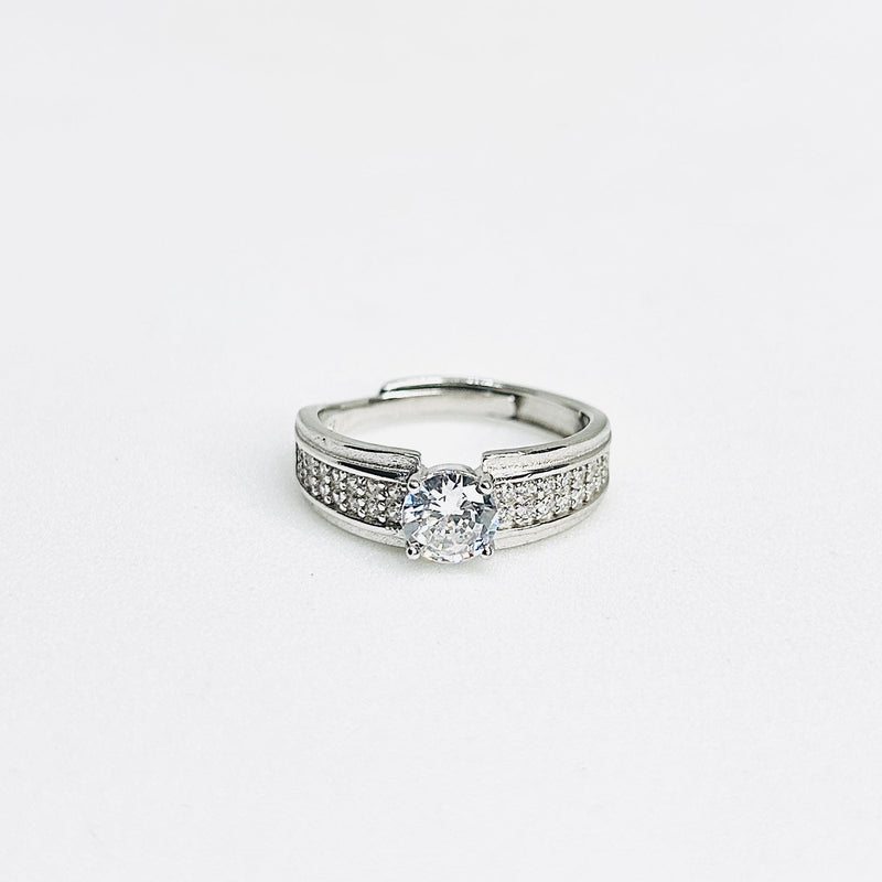 Silver ring with a diamond on a light gray background